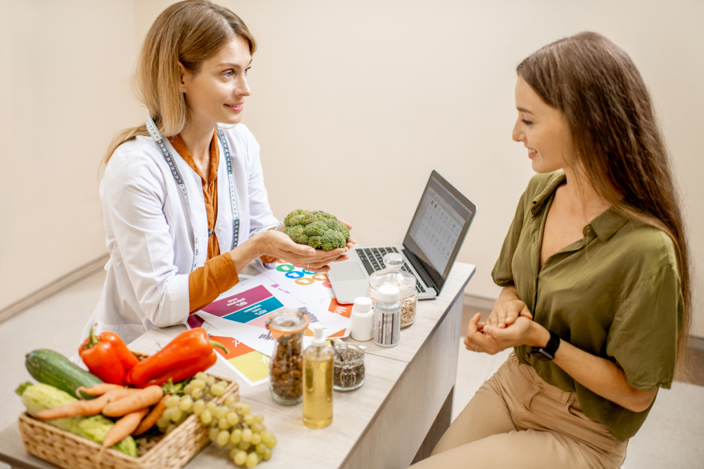 Nutritionist with young woman client talking about meal plan and healthy products during a medical consultation in the office